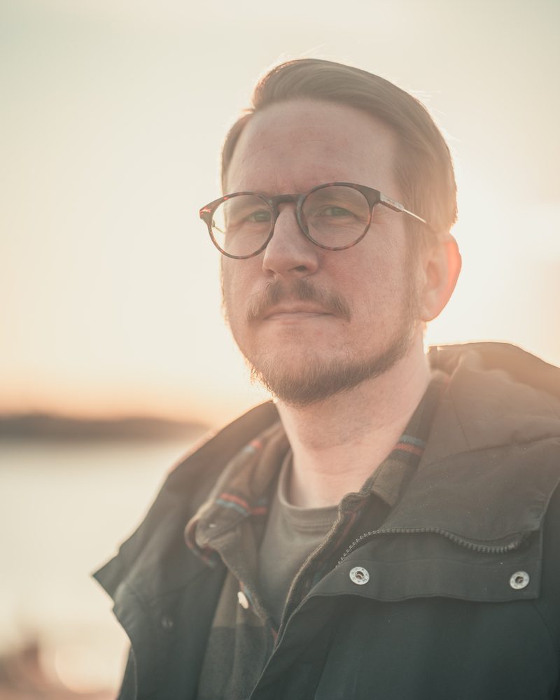 Joona Mielonen katsoo kameraan meren rannalla Kotkassa